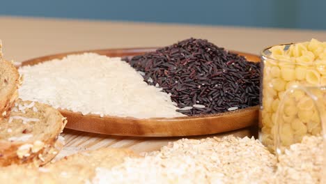 a variety of grains and sliced bread arranged on a wooden table under soft lighting, showcasing diverse textures and colors
