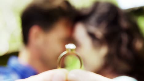 Close-up-of-romantic-couple-holding-engagement-ring