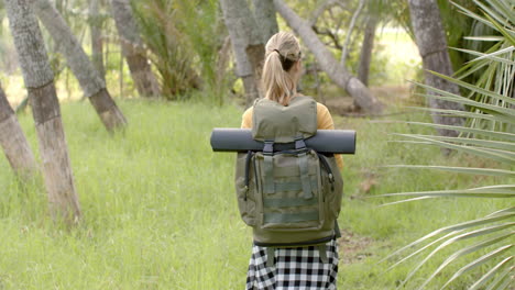 Una-Joven-Caucásica-Con-Una-Mochila-Está-Lista-Para-Una-Caminata-Por-El-Bosque-Con-Espacio-Para-Copiar