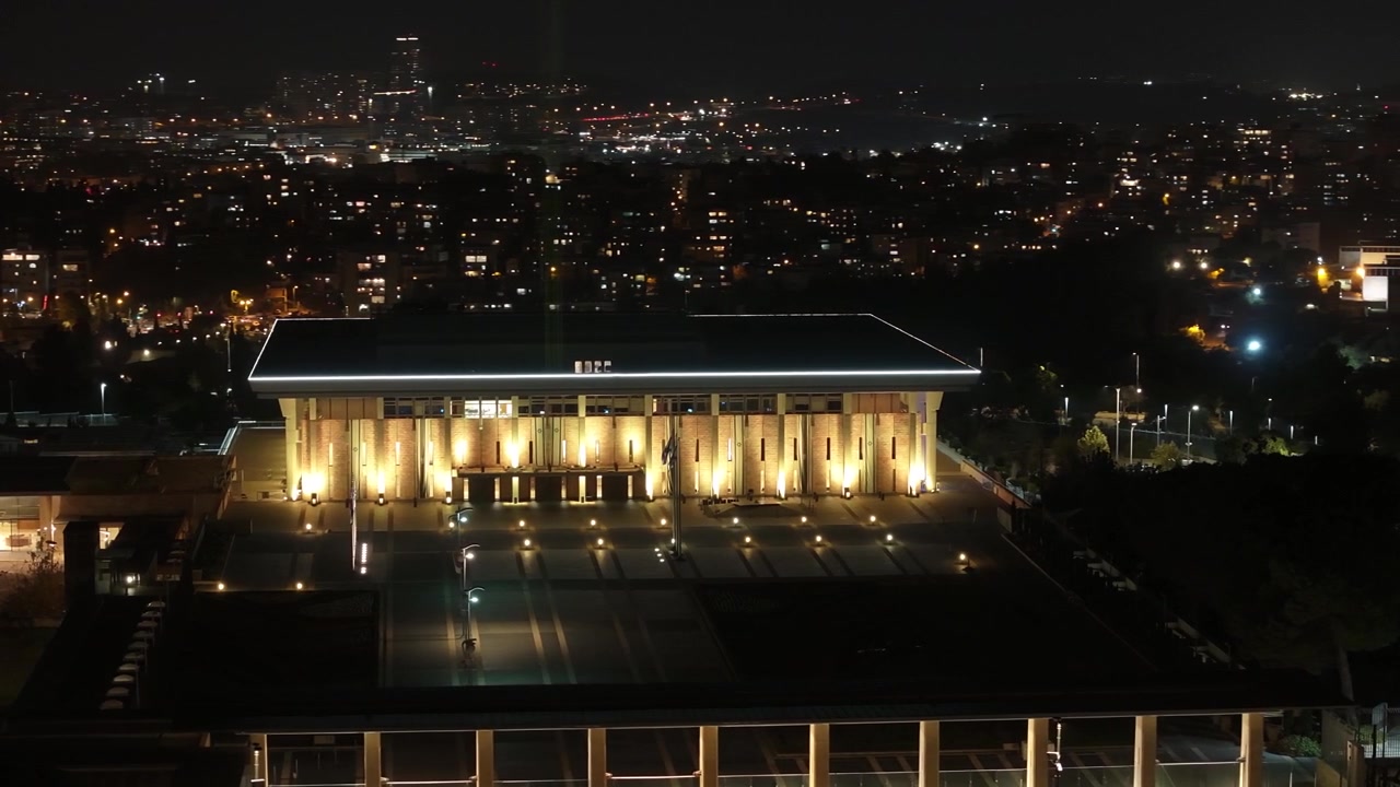 Facciata esterna illuminata dell'edificio del parlamento israeliano e della piazza nazionale durante le ore serali a Gerusalemme