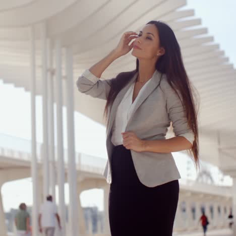 mujer elegante con el pelo largo de pie en un móvil