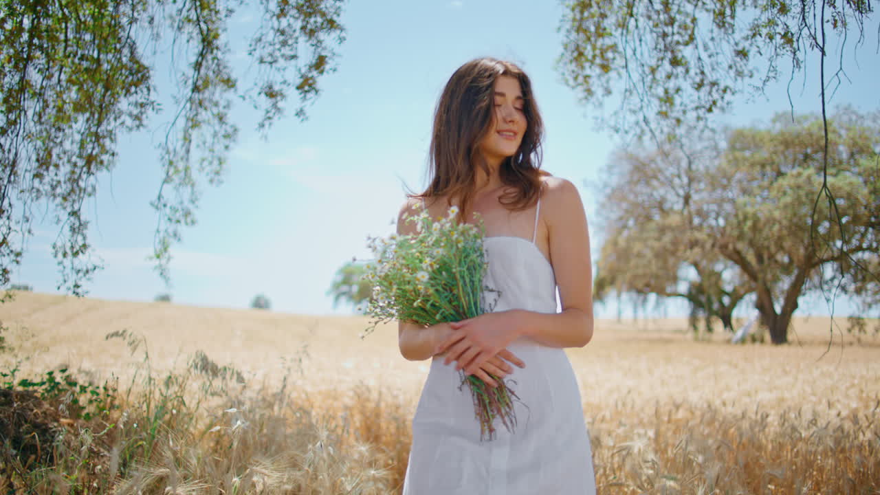 정원에서 야생 꽃을 들고 있는 만적인 여자. 카모밀을 고 있는 편안한 소녀