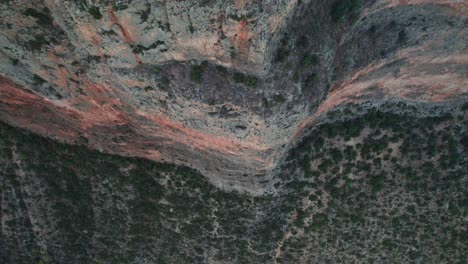 Drohne-Steigt-Von-Oben-Nach-Unten-über-Eine-Einschüchternde-Steile-Klippe-Mit-Trockener-Strauchlandschaft-Hinab,-Nach-Oben-Geneigt,-Rückzug-Nach-Leonidio,-Griechenland