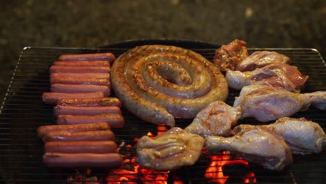 barbecue of sausages and chicken pieces to the grill, evening gathering at home with friends and family