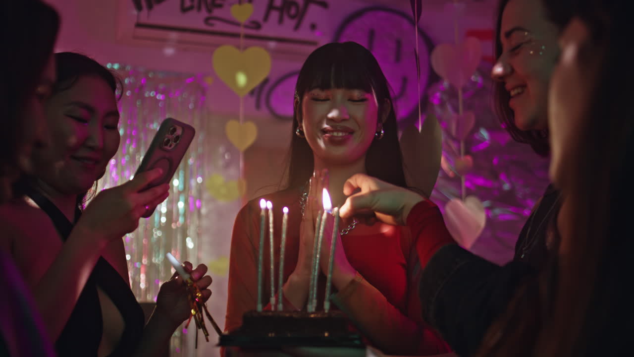 girl celebrating birthday in nightclub closeup. Friends burning candles