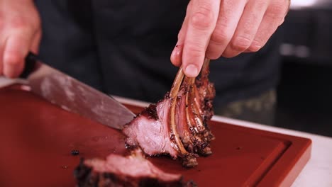 chef cutting grilled lamb ribs