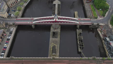 Newcastle's-swing-bridge-over-the-river-tyne,-with-surrounding-cityscape-in-england,-aerial-view