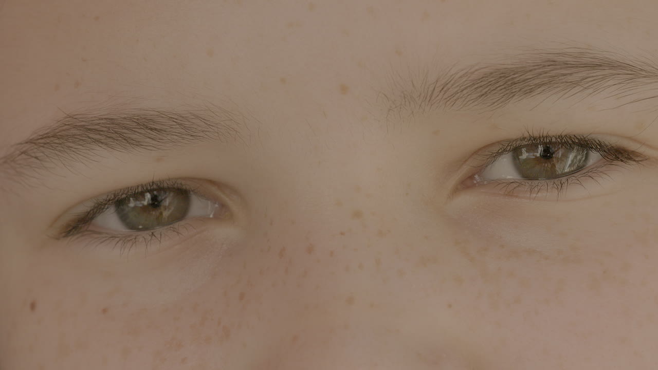 Primer plano de los hermosos ojos marrones de una linda adolescente mirando a la cámara