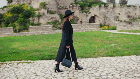 woman walking on the stone path inside the square under the castle