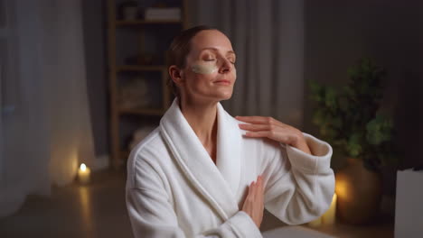 woman in robe applying beauty treatment at home