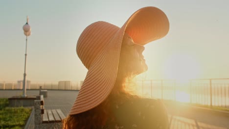 woman in hat enjoying the sunset