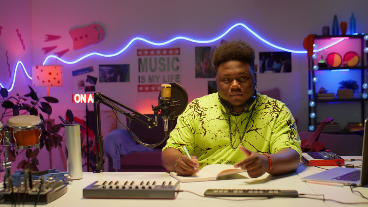 African American Man Writing Music in Recording Studio