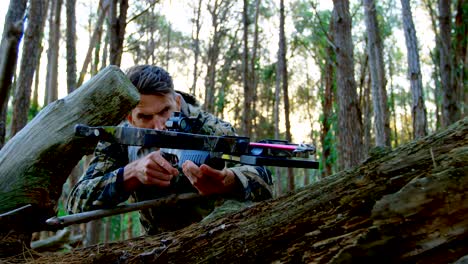 man aiming with compound bow in the forest 4k