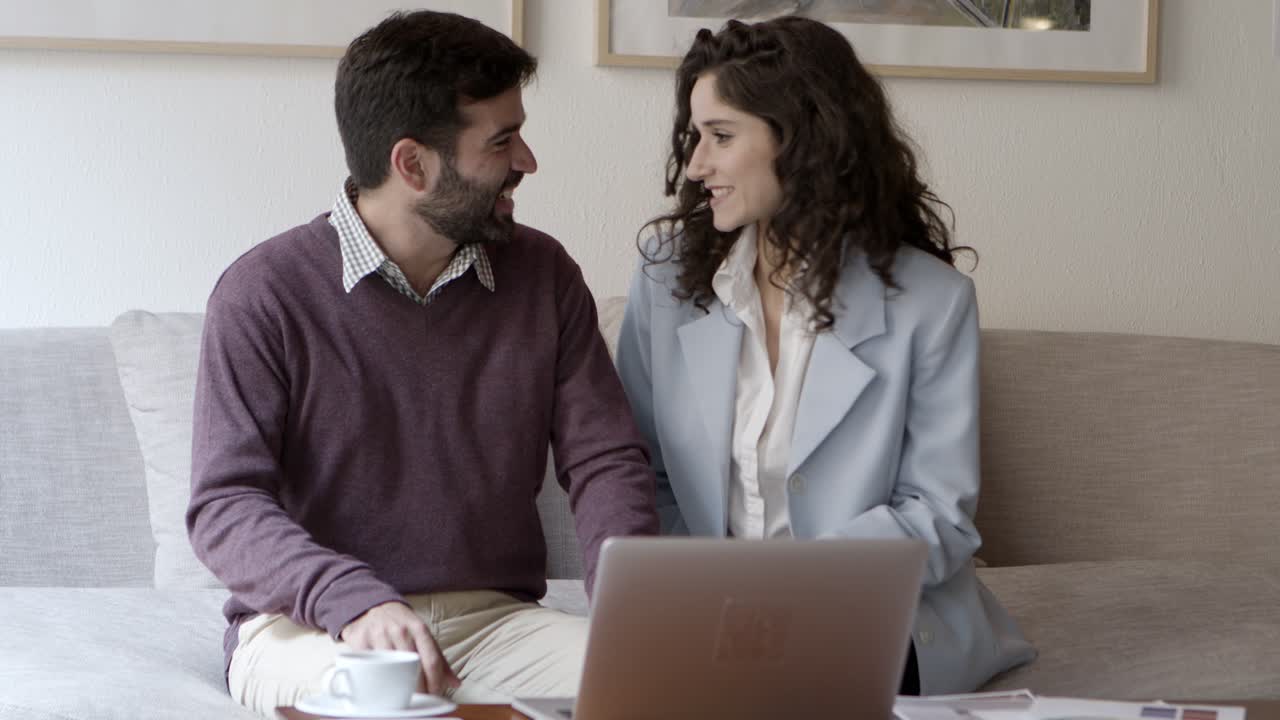 Donna e uomo felici in videochiamata tramite laptop