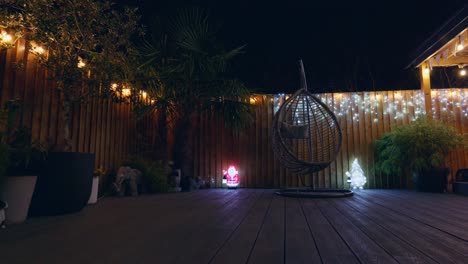 imágenes al aire libre de un jardín minimalista por la noche con iluminación cálida, luces de hadas y decoraciones navideñas