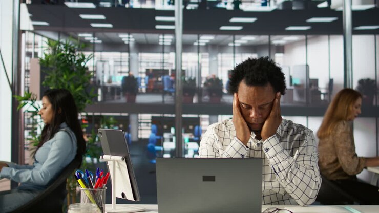 Stressed man in office with laptop