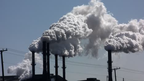 a power plant with smokestacks belches smoke into the air 2