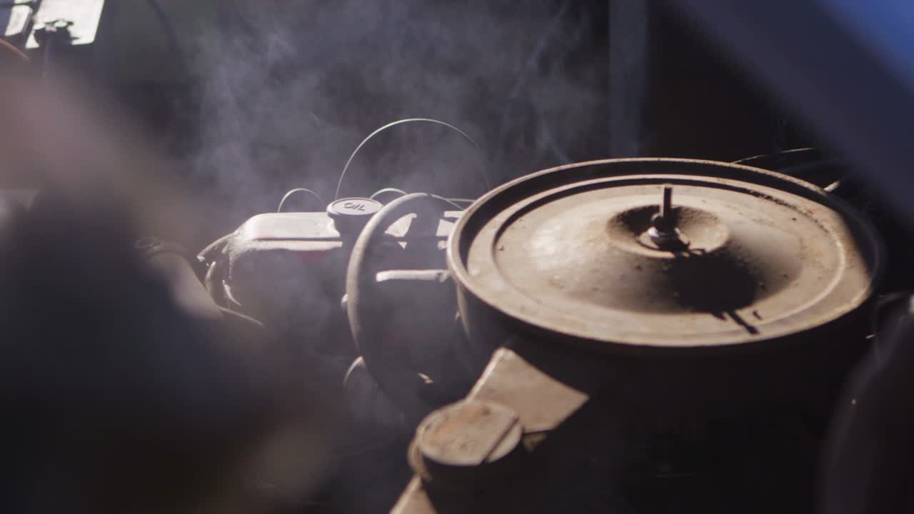 primer plano de un viejo motor de camioneta chevy mientras se vaporiza y los dedos señalan las piezas problemáticas 1