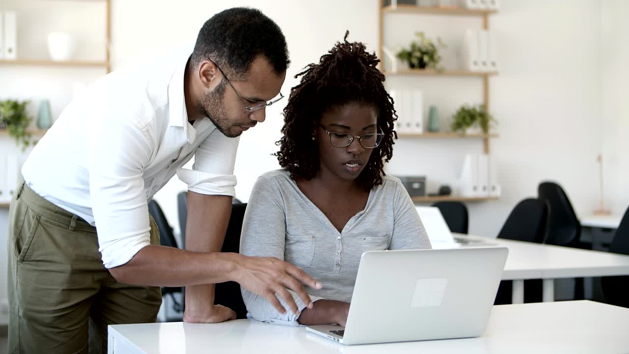 Frontvisning af koncentrerede medarbejdere, der arbejder med bærbar computer