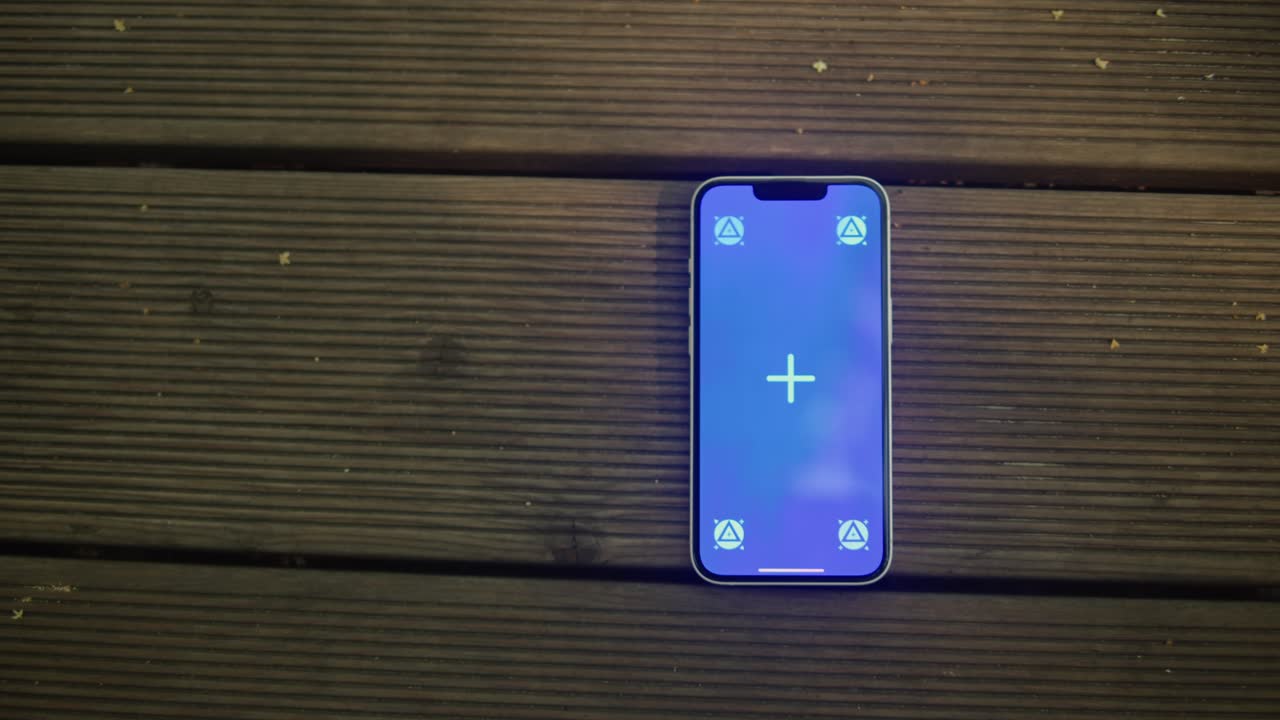 Phone with chroma key screen on the wooden background close-up. Green screen on smart phone. Nature