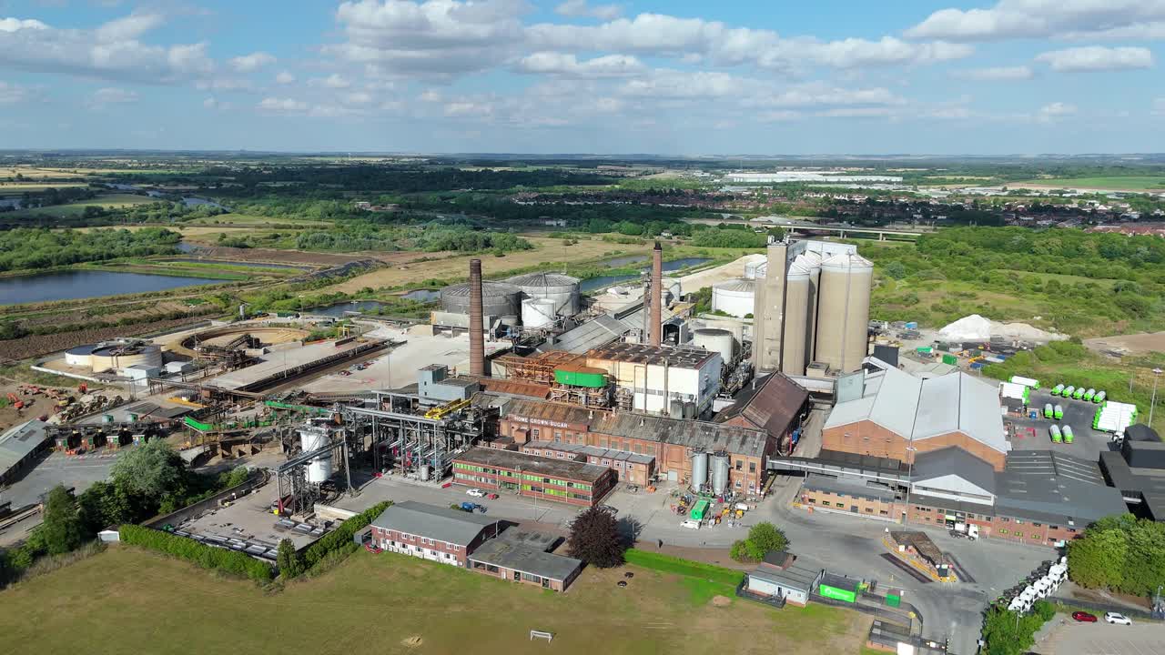 High aerial footage of sugar factory with storage tanks and industrial chimneys UK