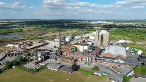 high aerial footage of sugar factory with storage tanks and industrial chimneys uk
