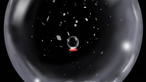 animation of christmas snow globe with snow falling on black background