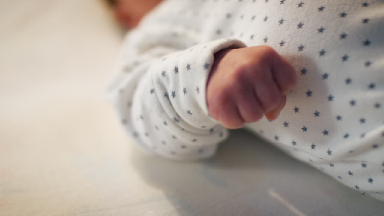 Neonato sdraiato sulla schiena nella culla della cameretta all'ora della nanna.