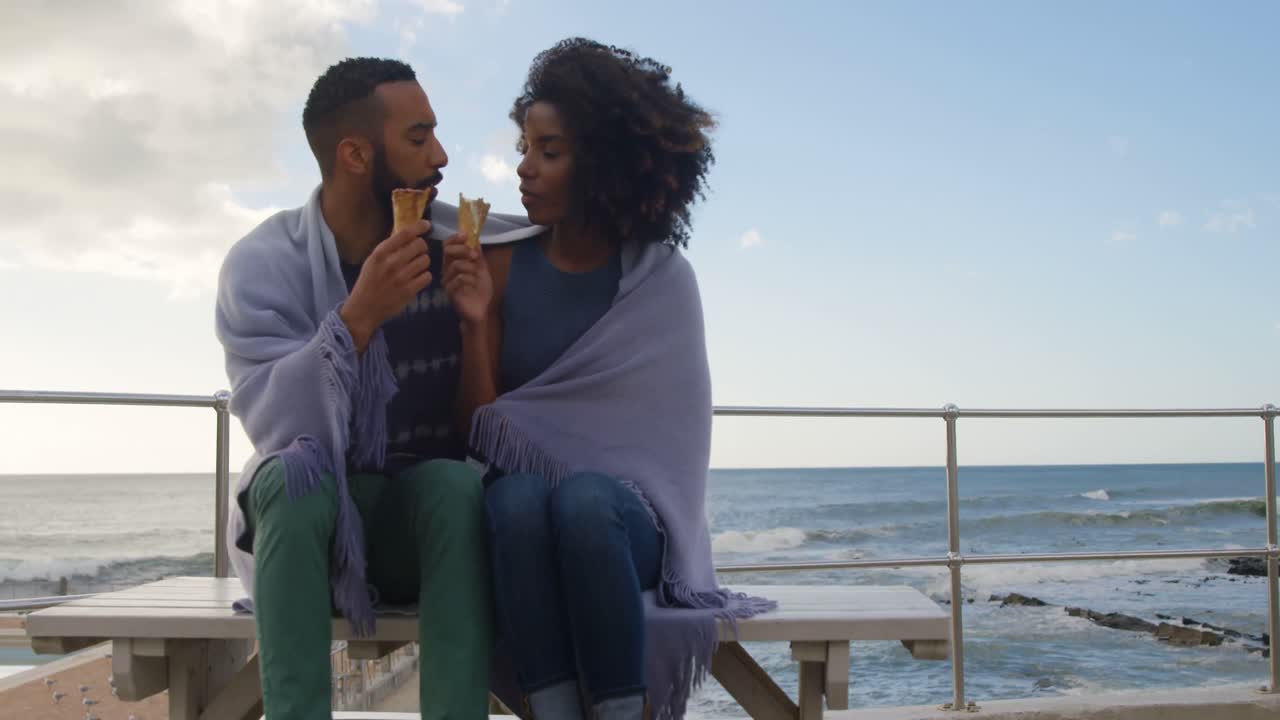 Coppia che gusta un cono gelato in spiaggia 4k