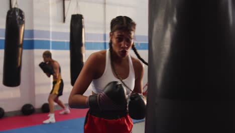 mixed race woman boxing in punchbag