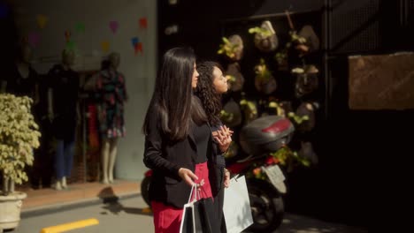 two women shopping and walking out of a clothing store