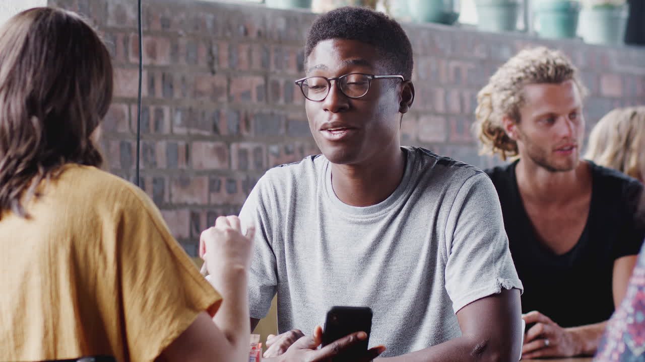 Young Couple Meeting Sitting At Table In Coffee Shop And Talking