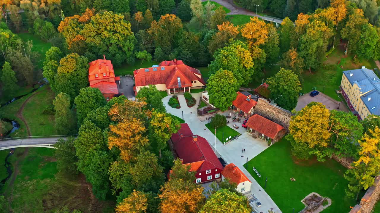 Scenic aerial view of historic Valmiera castle complex and trees in evening sunlight