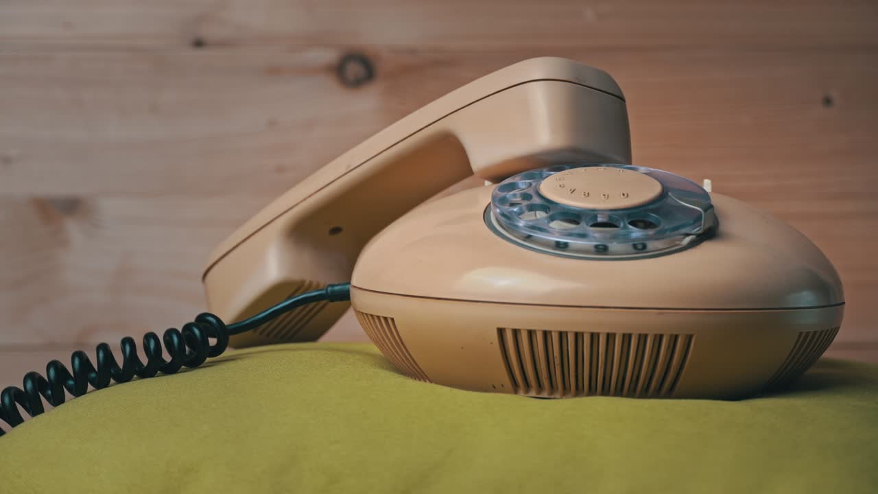 오래된 가정 유선 전화는 나무 배경에 회전하고 있습니다