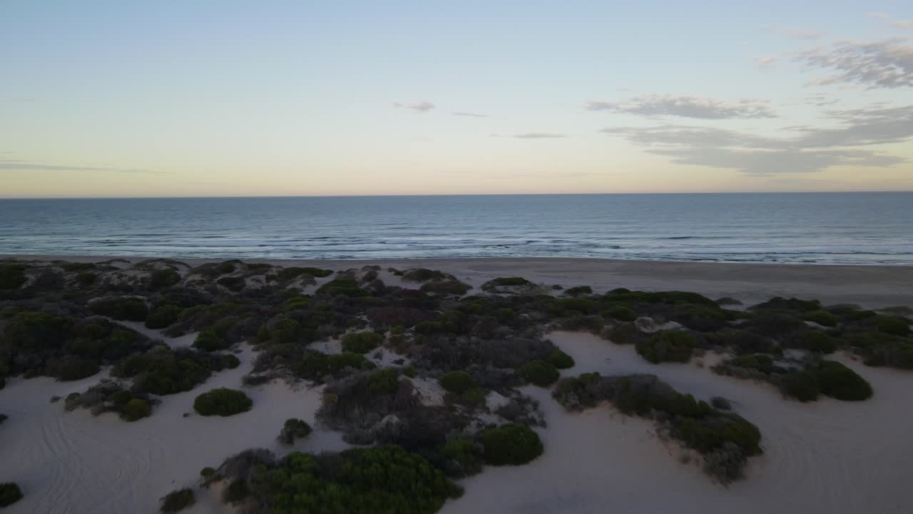 drone aéreo que va hacia la playa desde el campamento durante el amanecer