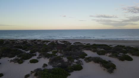 drone aéreo que va hacia la playa desde el campamento durante el amanecer
