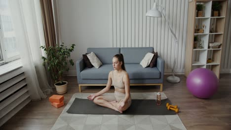 woman practicing yoga and meditation at home