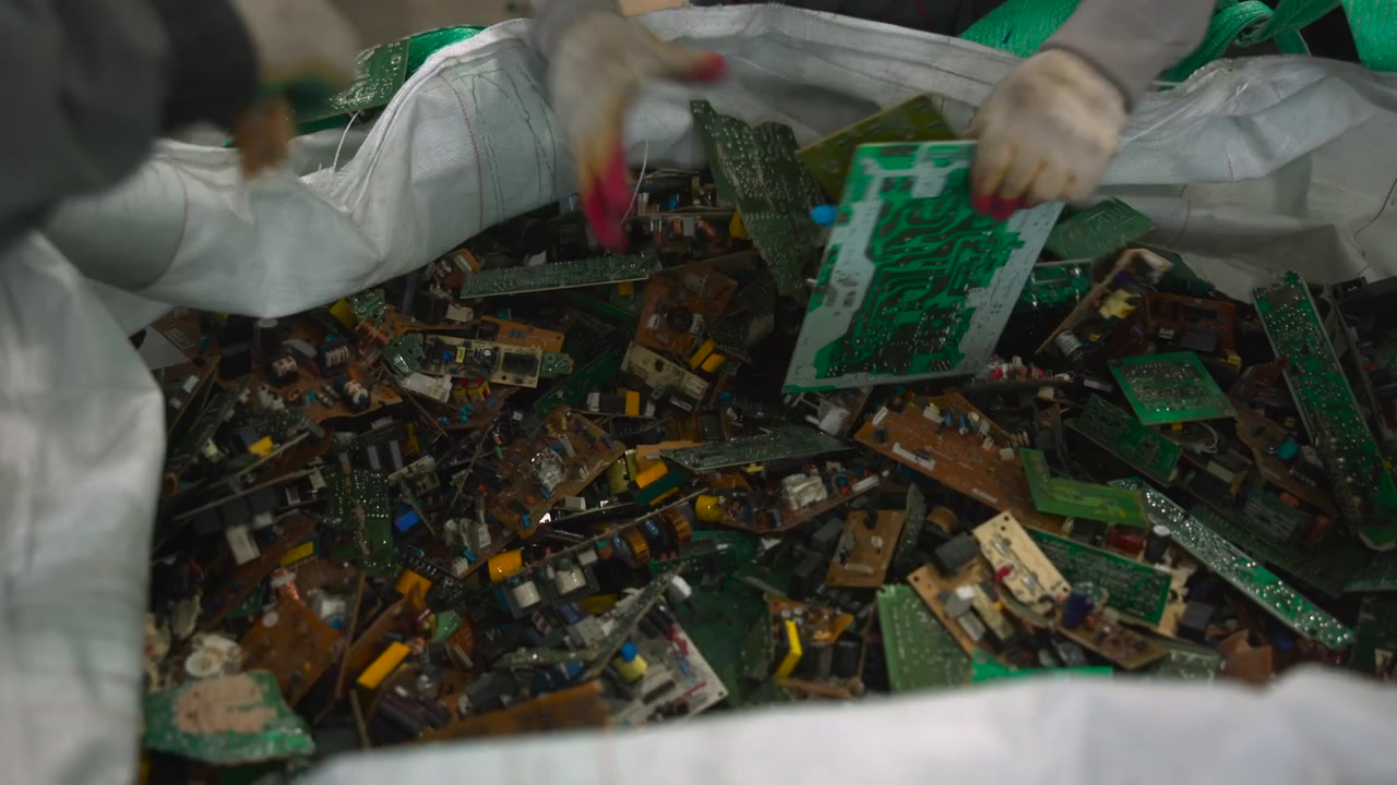 Multiple Workers Sorting Circuit Board Pile, Coordinated Manual Processing With Gloved Hands Extracting