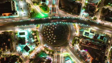 Hiperlapso-De-La-Rotonda-De-La-Autopista-Nocturna-Iluminada-Con-Luces-De-Neón,-Tráfico-Aéreo-De-Automóviles-Y-Vida-Nocturna-En-Santiago-De-Chile,-Dron-Volador