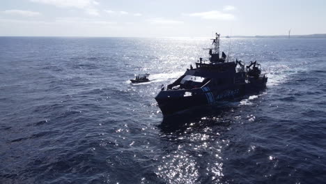 fantastica toma aerea de una patrulla de policia junto a uno de los barcos que pasan