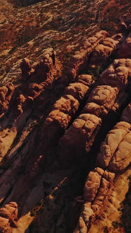 land of rocks with no greenery and rounded mountains. aerial view of sunny desert in utah, usa. vertical video
