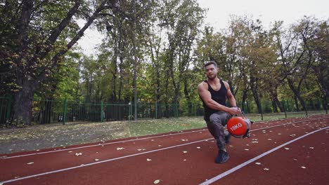 fitness man exercises outdoors in autumn. healthy sportsman training his muscular body with weight in the modern stadium.