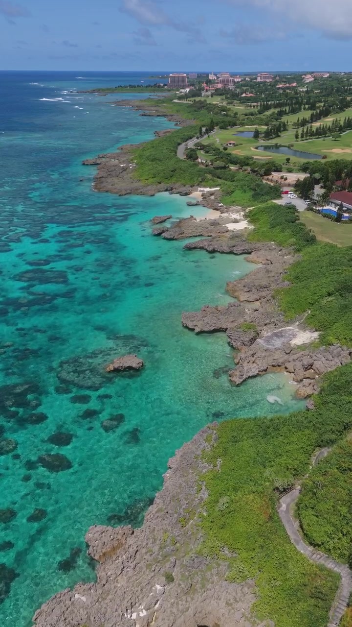 Costa rocciosa e acque limpide color turchese presso il Giardino Marino di Imgyaa sull'isola di Miyako a Okinawa, Giappone. Ripresa aerea con avvicinamento.