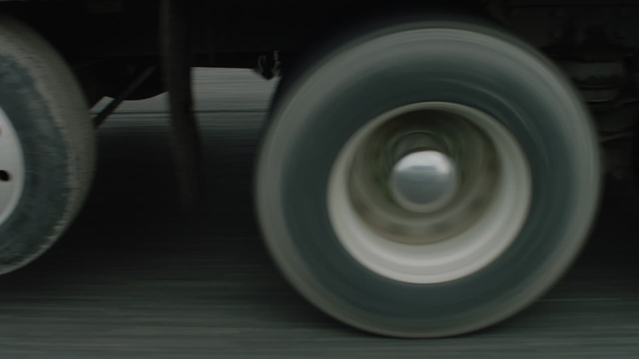 Tracking shot alongside a trucks wheels traveling along a freeway.