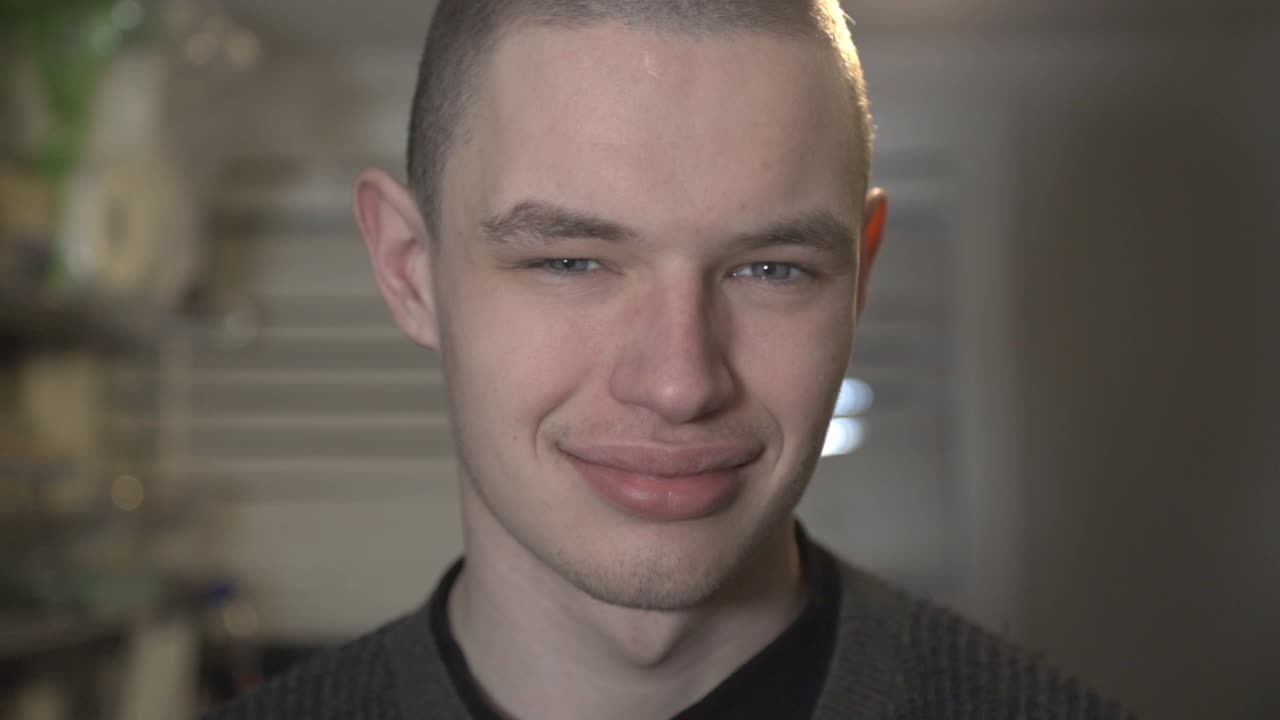 A Young Man Smiling While Looking At The Camera - Closeup Shot