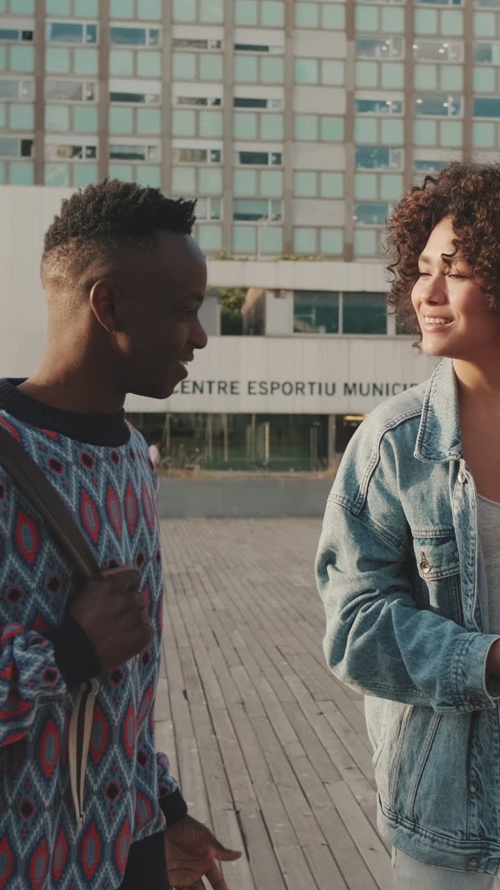 Two people walking and talking in an urban setting