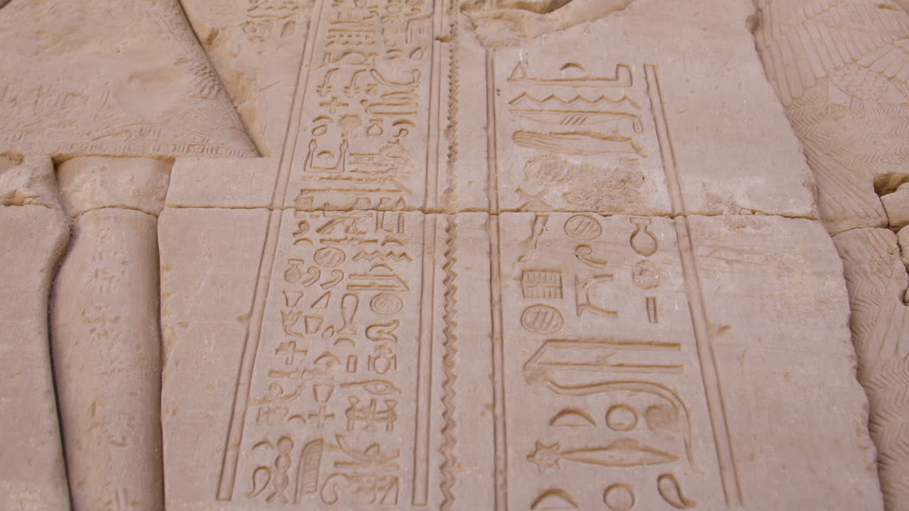 Ancient Egyptian hieroglyphs carved into stone at the Dendera Temple in Egypt