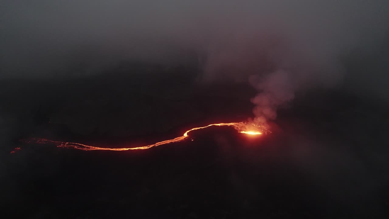 un drone in senso antiorario del vulcano litli hrutur in islanda con nebbia e fumo