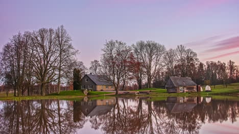 two beautiful cottages in the countryside reflecting on a lake