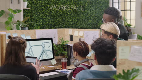 joven equipo de ingenieros desarrollando prototipos de bicicletas utilizando computadora visualizando diseño 3d en pantalla intercambiando ideas sobre el desarrollo futuro colaborando en un espacio de trabajo de oficina creativo